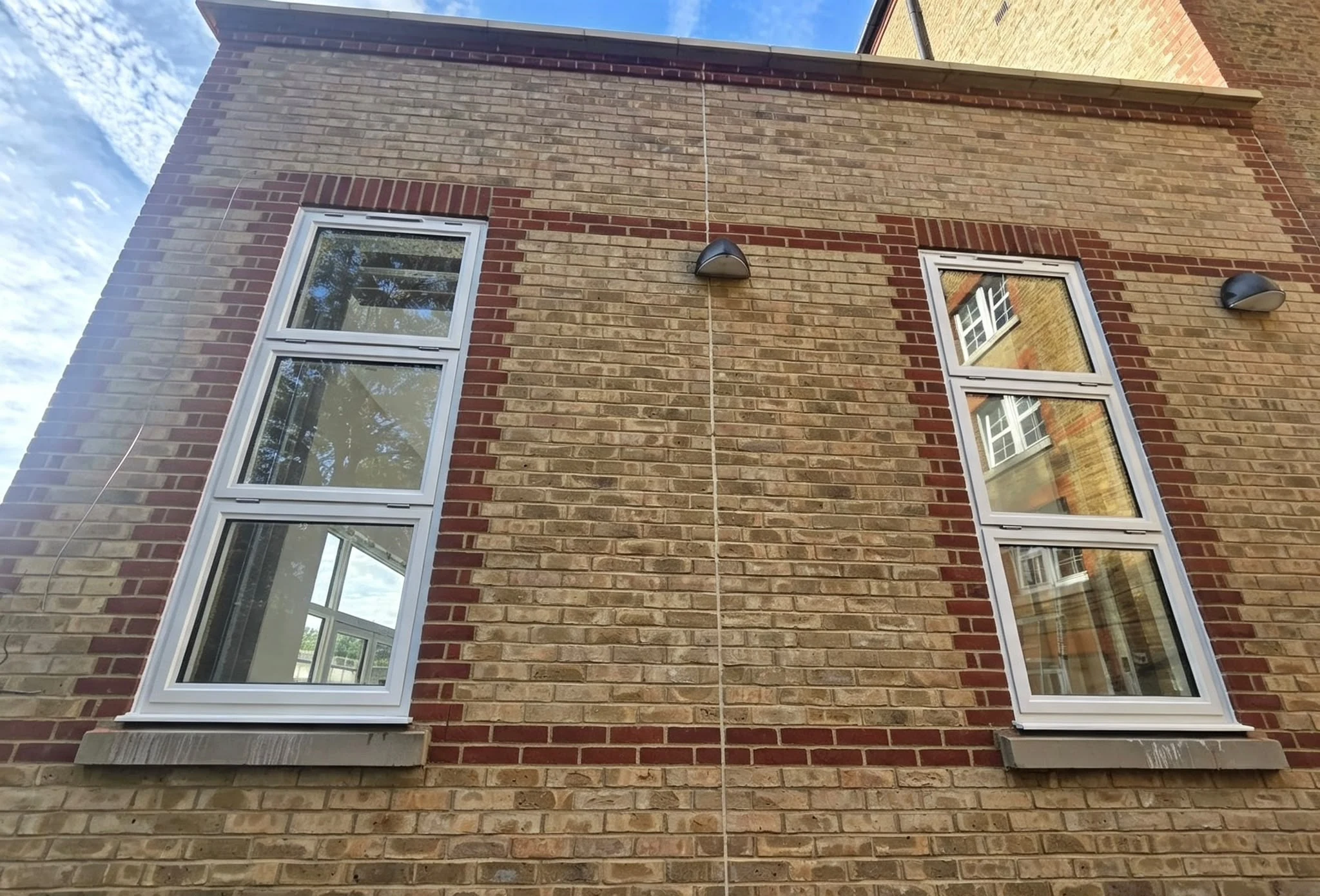 Tall three-light windows set into the brick detailing
