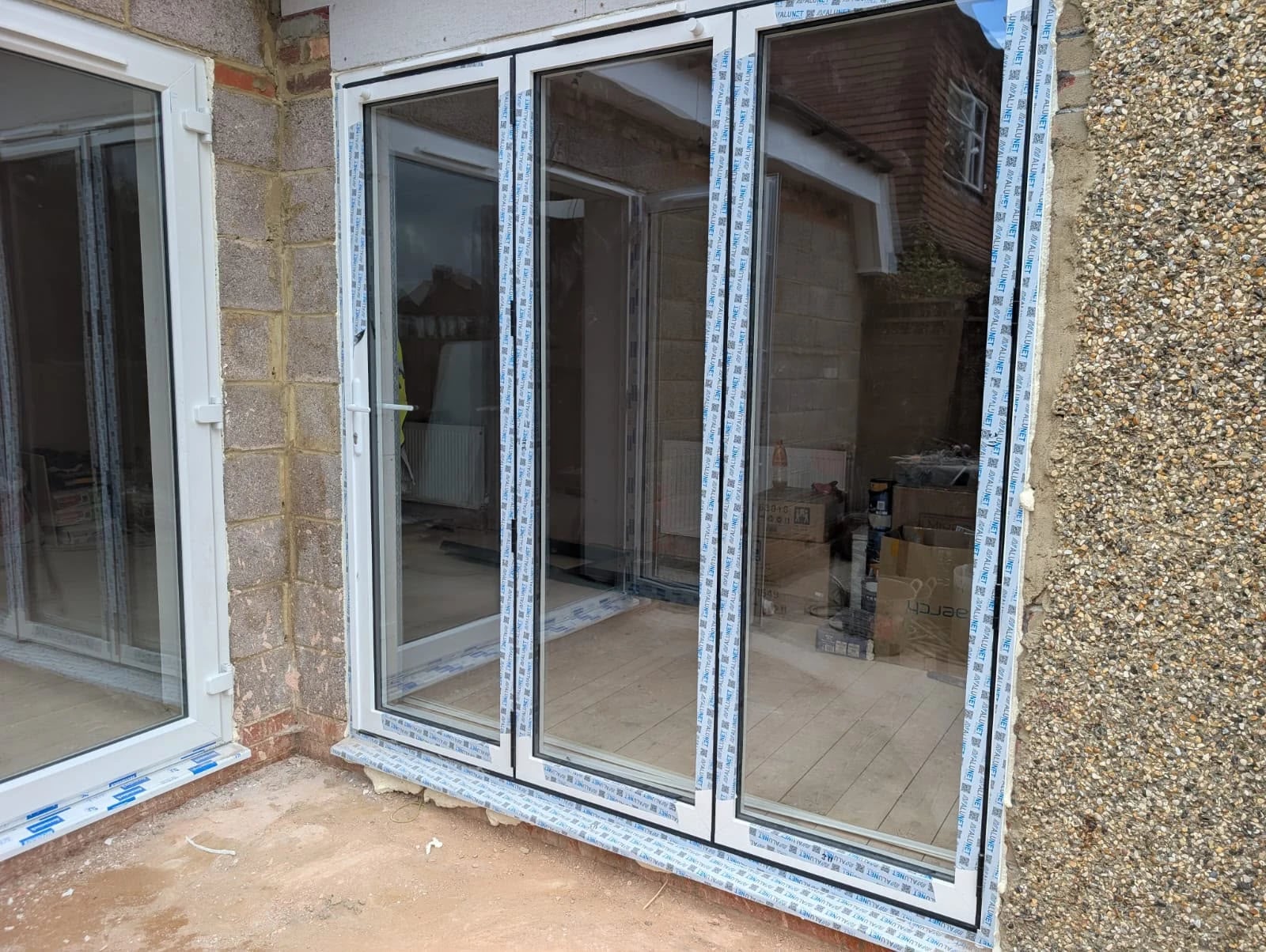 Three-pane Alunet aluminium bi-fold, fitted with the protective film still on