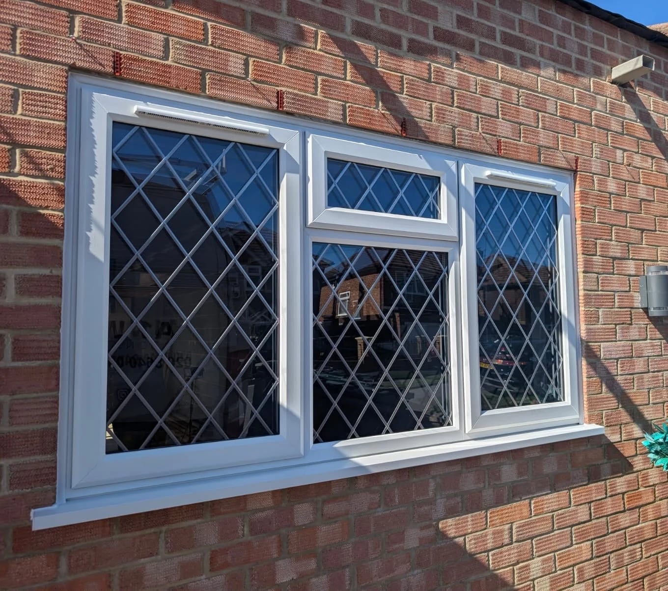 Three-light casement with diamond leaded glazing and a top-opening fanlight