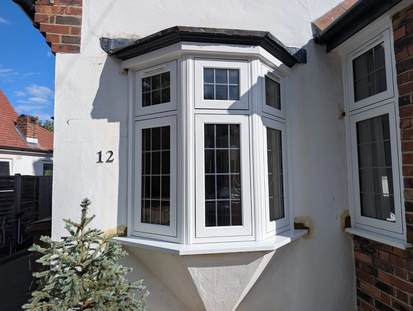Front bay beside the door, with rectangular leaded lights in every pane