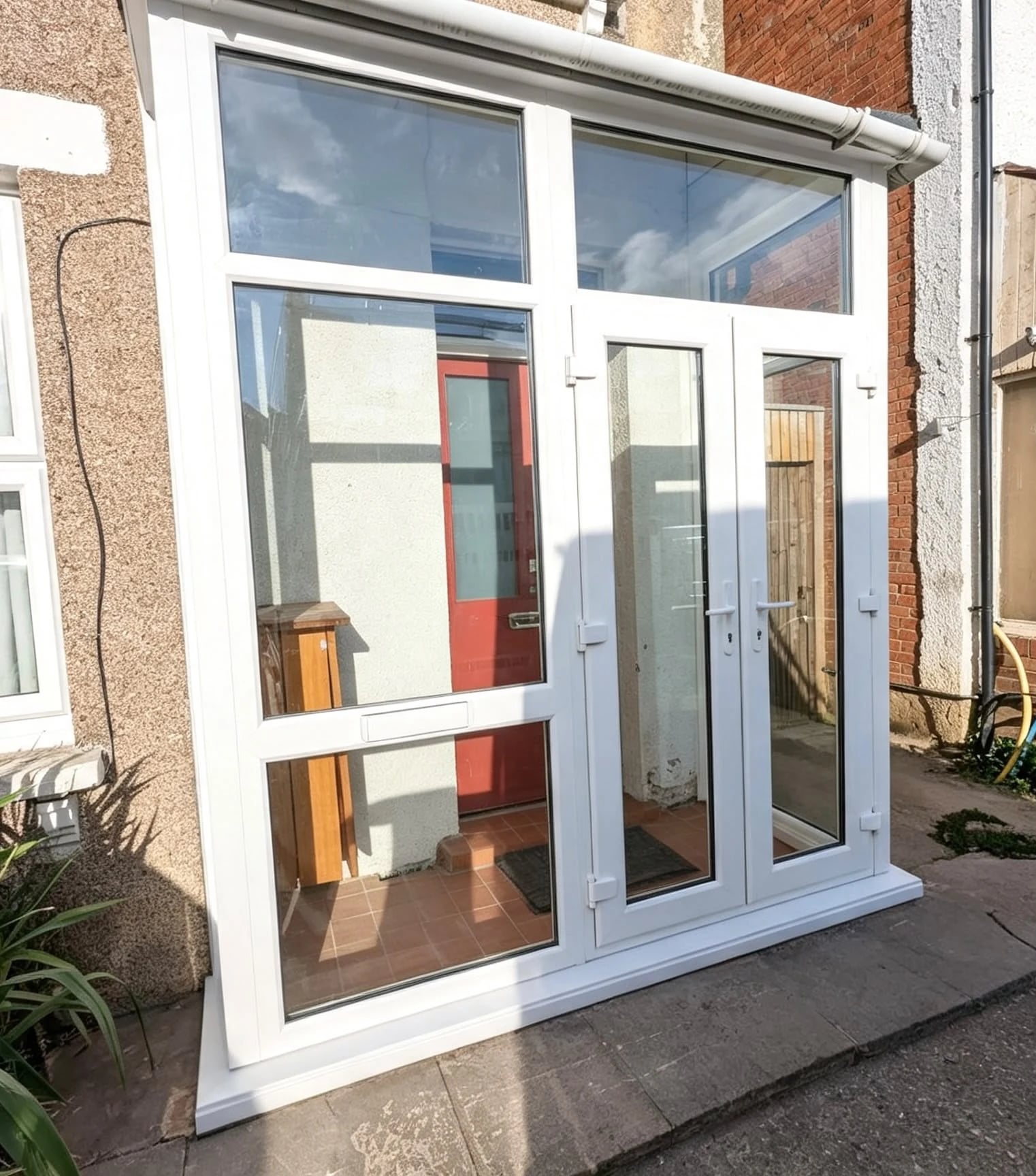 Front view: French doors beside a large fixed side panel with a built-in letterbox