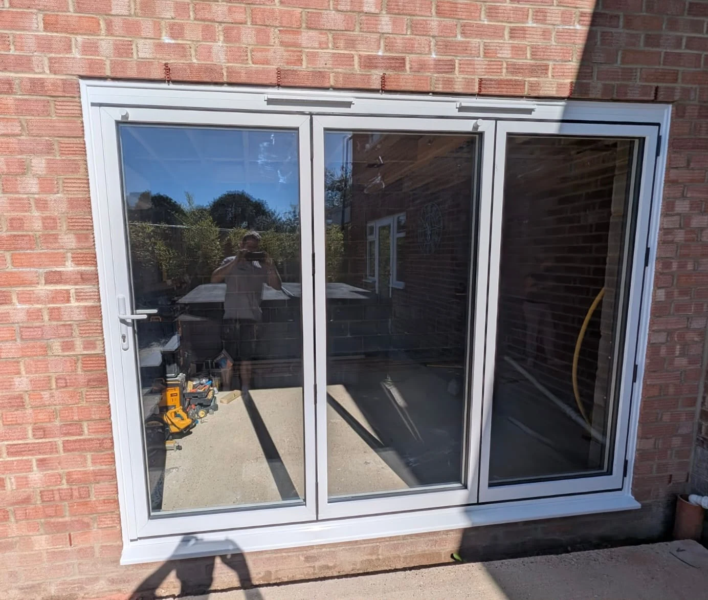 Three-pane white bi-fold doors opening onto the back of the house